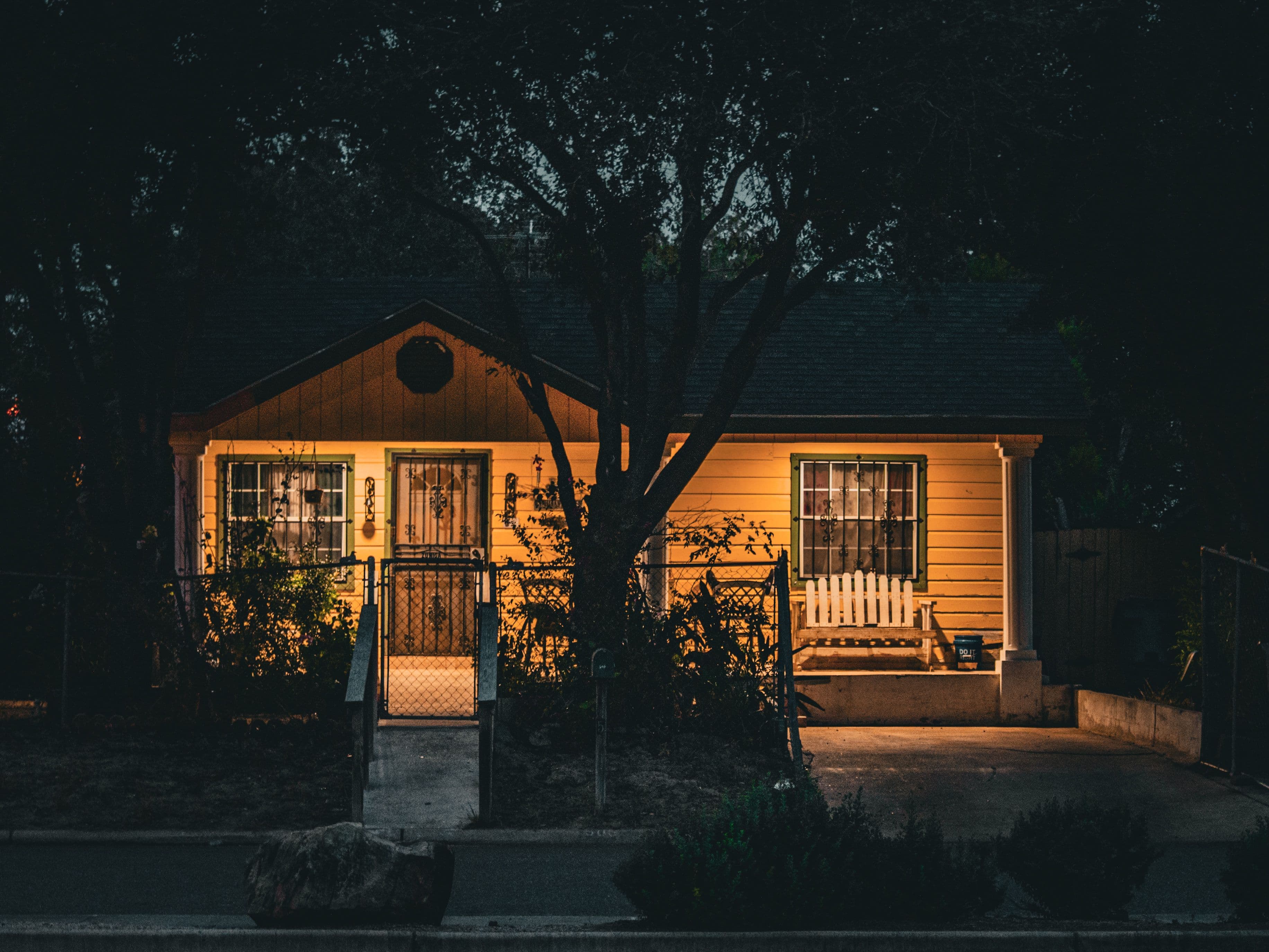 A house at night, porch and windows lit against the dark